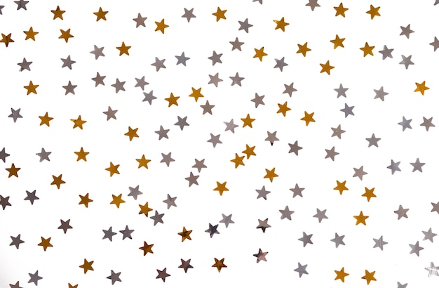 Photo golden and silver stars glitter on a white isolated background.