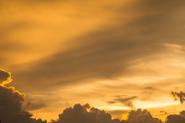 Cielo e nuvole dorati prima del fondo di tramonto