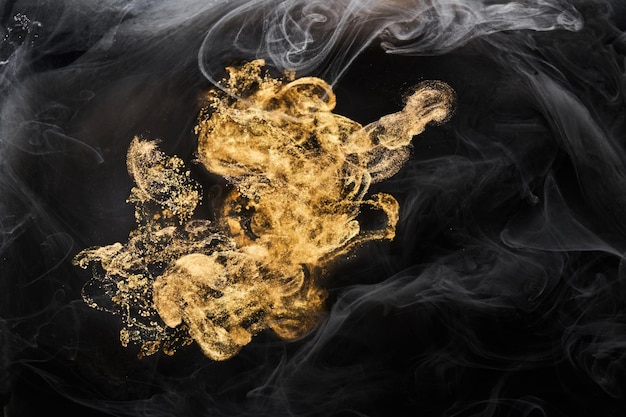 Golden sparkling abstract background luxury black smoke acrylic paint underwater explosion cosmic swirling ink