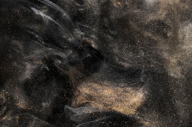 Golden sparkling abstract background luxury black smoke acrylic paint underwater explosion cosmic swirling ink