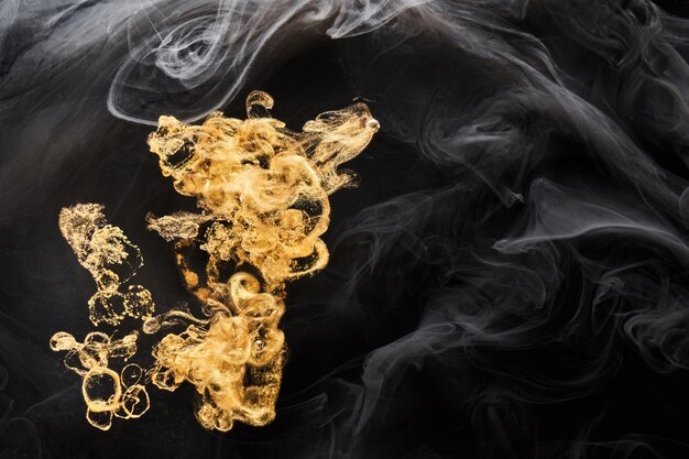 Золотой сверкающий абстрактный фон, роскошный черный дым, акриловая краска, подводный взрыв, космические закрученные чернила