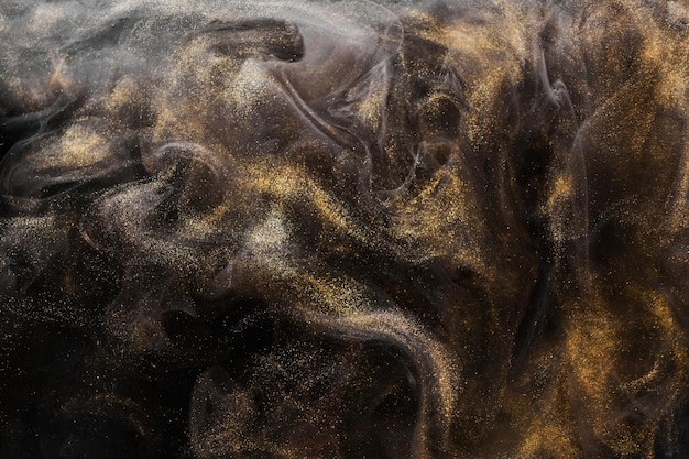 Golden sparkling abstract background luxury black smoke acrylic paint underwater explosion cosmic swirling ink