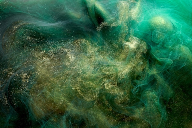 Golden sparkling abstract background luxury green smoke acrylic paint underwater explosion cosmic swirling ink