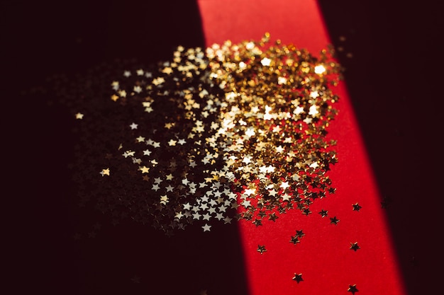 Golden star confetti in harsh light with shadow