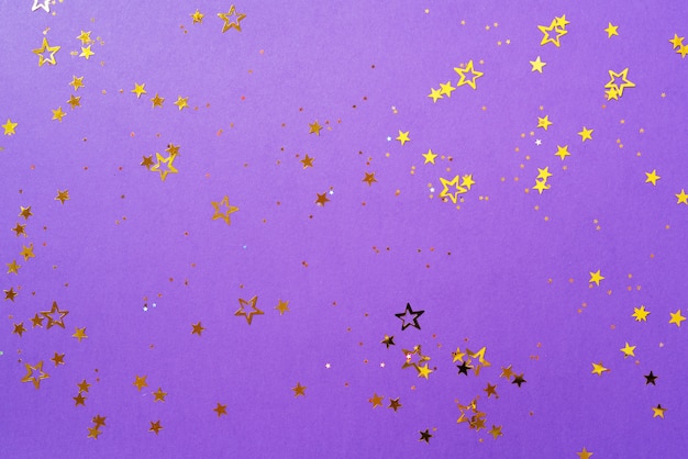 Golden star sparkles on violet background