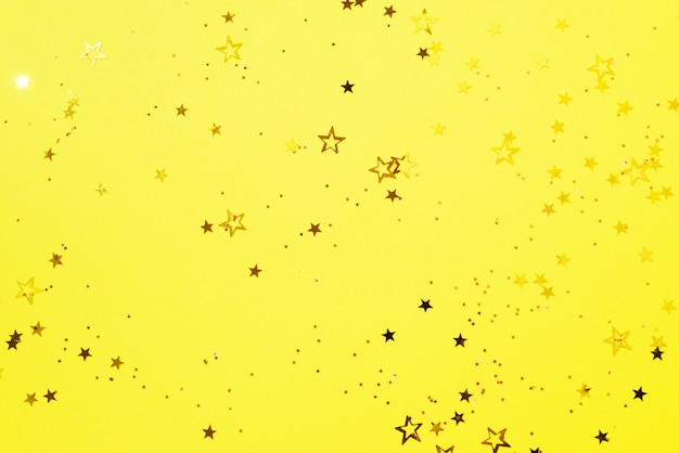 Golden star sparkles on yellow background