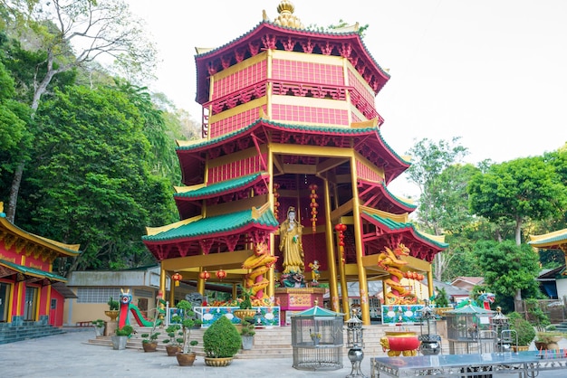 Golden statue of goddess Guanyin in red pagoda near Tiger Cave Temple in Krabi, Thailand