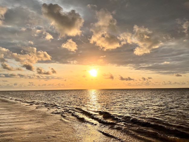 Photo golden sunrise waves with white sandy beach