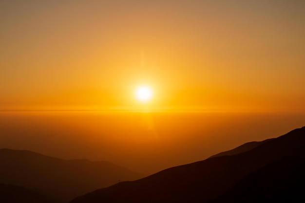 golden sunset between fog and mountains