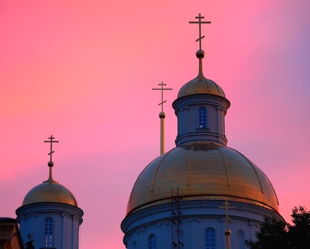 Golden temple domes during pink sunset