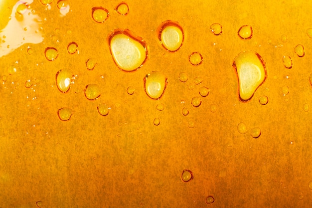 Golden texture of cannabis wax, marijuana dab background.