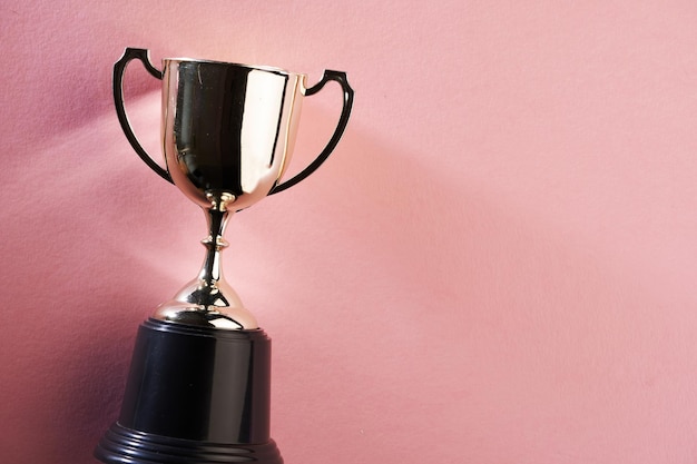 Golden trophy on pink background