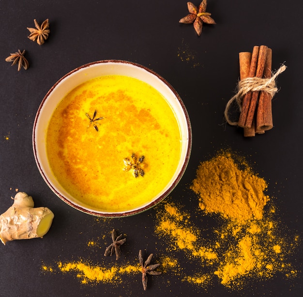 Golden turmeric latte milk with curcuma powder in a big cup