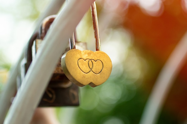 Golden wedding lock with two hearts on it.Symbol of love.Sunshine on background.