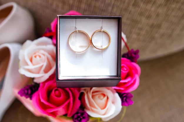 Golden wedding rings in a box and modern bouquet