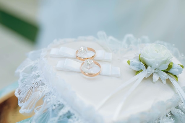 Golden wedding rings on decorated little pillow