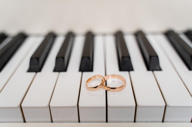 Golden wedding rings on piano keys closeup