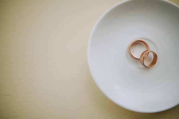 Golden wedding rings on white plate