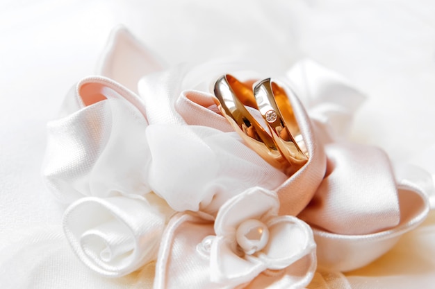 Golden wedding rings with diamond on silk roses