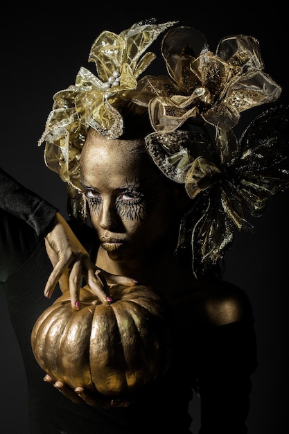 Golden woman with halloween pumpkin