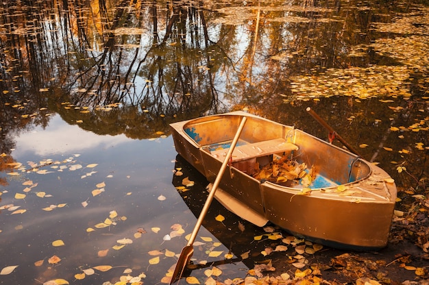 Golden wooden boat at beautiful autumn sunny day autumn peaceful landscape with reflections