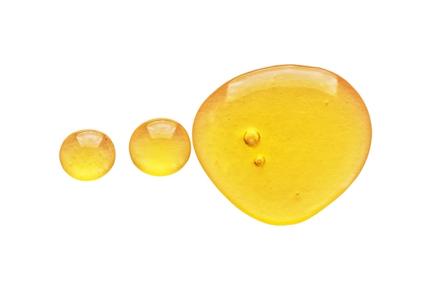 Golden yellow abstract oil bubbles or face serum drops isolated on white background