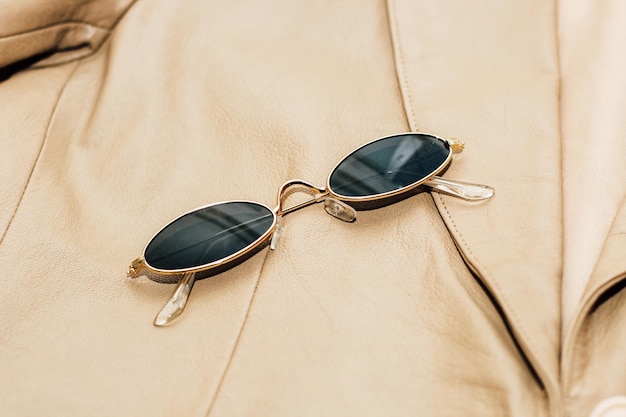 Photo goldrimmed sunglasses on the texture of a brown leather jacket genuine soft leather