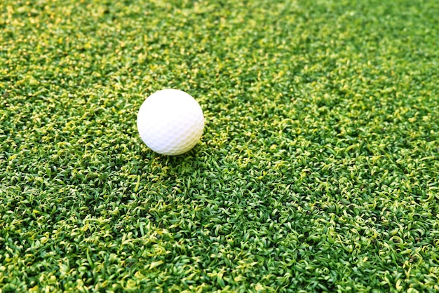 Golf ball close up on green grass on blurred beautiful\
landscape of golf backgroundconcept international sport that rely\
on precision skills for health relaxationx9