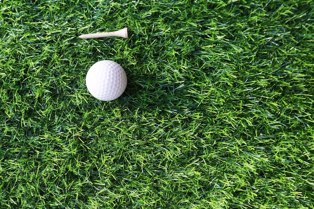 Мяч для гольфа крупным планом на зеленой траве на размытом красивом фоне гольфа