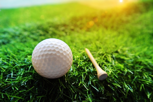 Мяч для гольфа крупным планом на зеленой траве на размытом красивом фоне гольфа