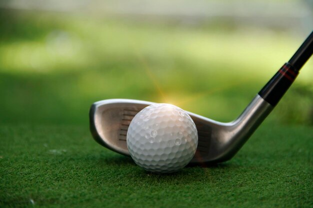 Golf ball and club on grass