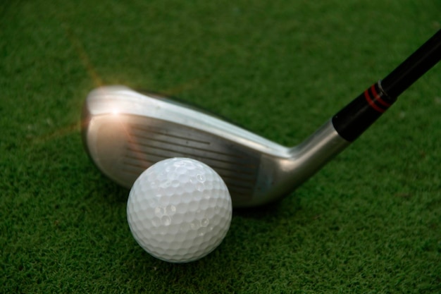 Golf ball and club on grass