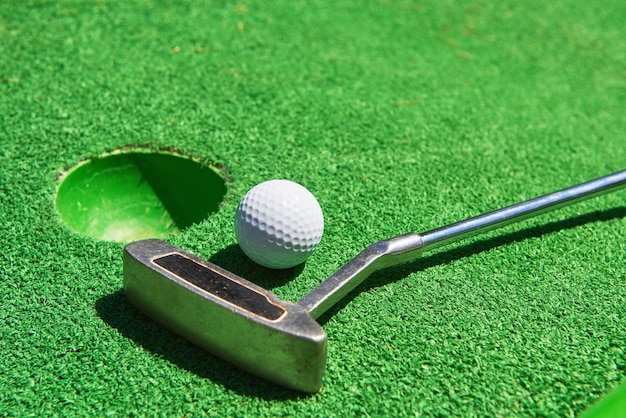 Golf ball and Golf Club on Artificial Grass.