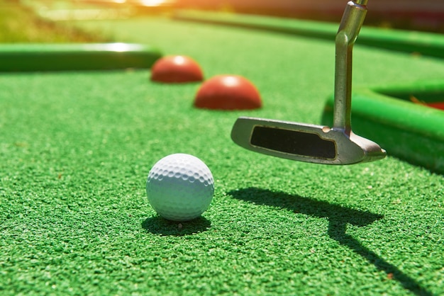 Photo golf ball and golf club on artificial grass.