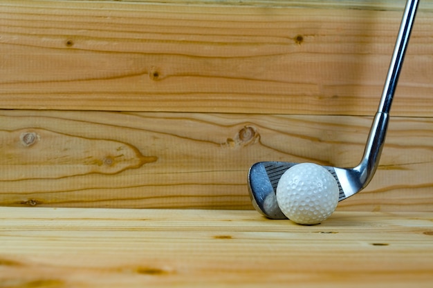 Golf ball and golf club  on wood floor