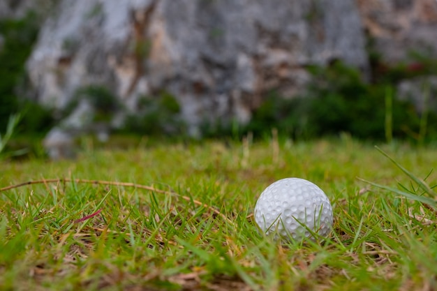 Golf ball on grass near  mountain