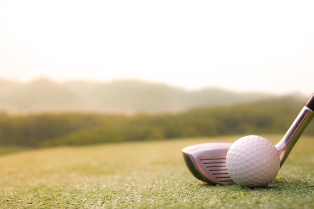 Photo a golf ball is placed on the grass with a mountain view behind