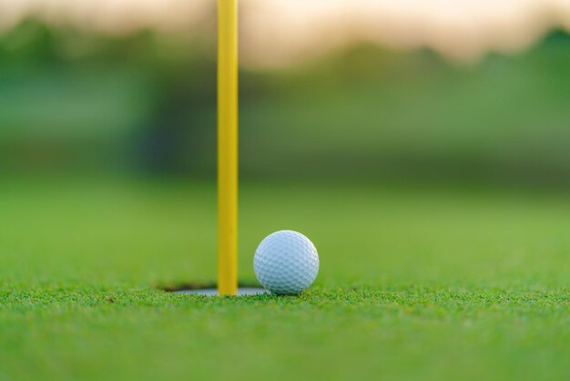 Photo golf ball on lip of cup at golf court