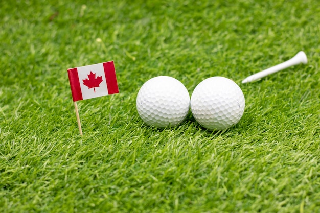 Photo golf ball with flag of canada on green grass.