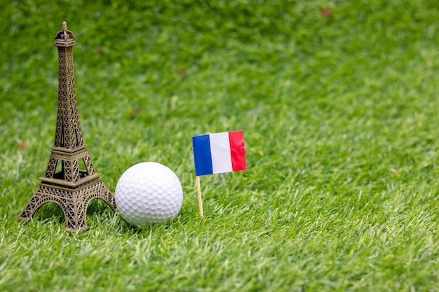 La palla da golf con la bandiera della francia è su erba verde.