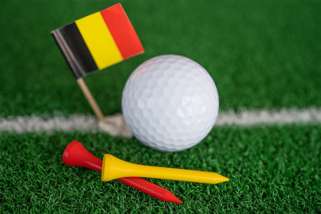 Golf ball with germany flag and tee on green lawn or grass is\
most popular sport in the world.