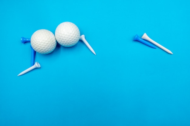 Le palline da golf sono sul blu con tee blu e bianco