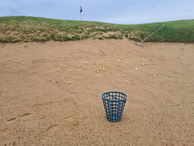 Golf balls in practice sand bunker closeup