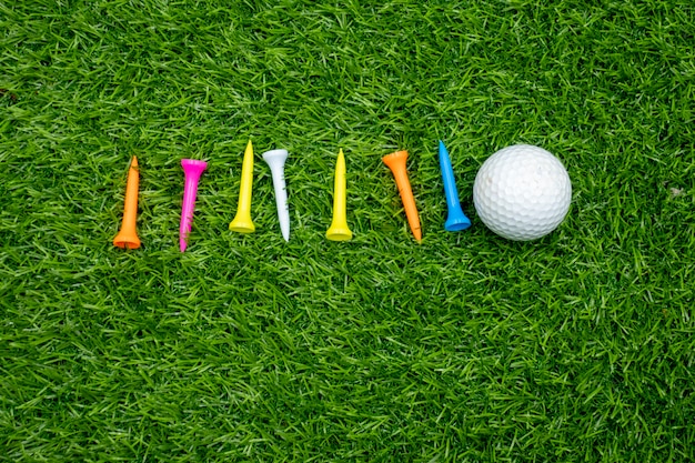 Foto palline da golf e tees sono su erba verde.