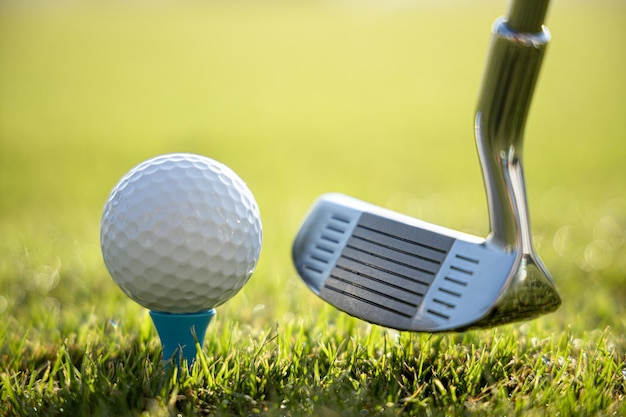 Golf club and ball on tee in front of driver