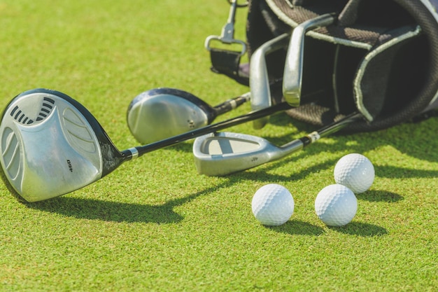 Photo golf clubs and balls on the lawn.