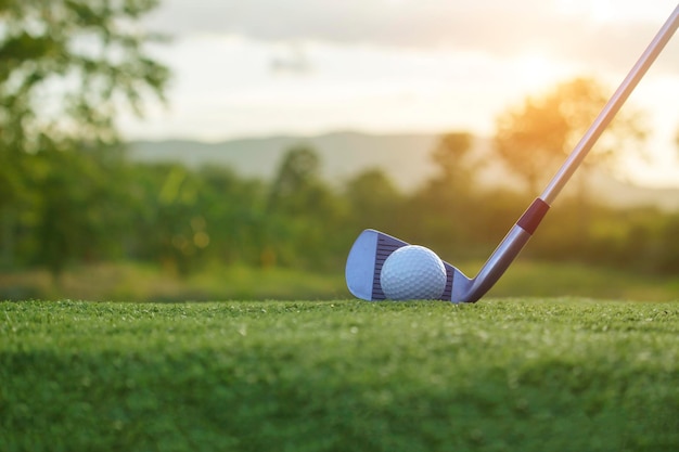 Golf clubs and golf balls on a green lawn in a beautiful golf course