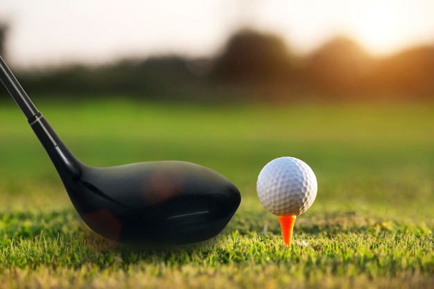 Golf clubs and golf balls on a green lawn in a beautiful golf course