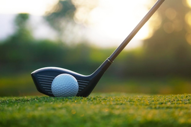 Golf clubs and golf balls on a green lawn in a beautiful golf course