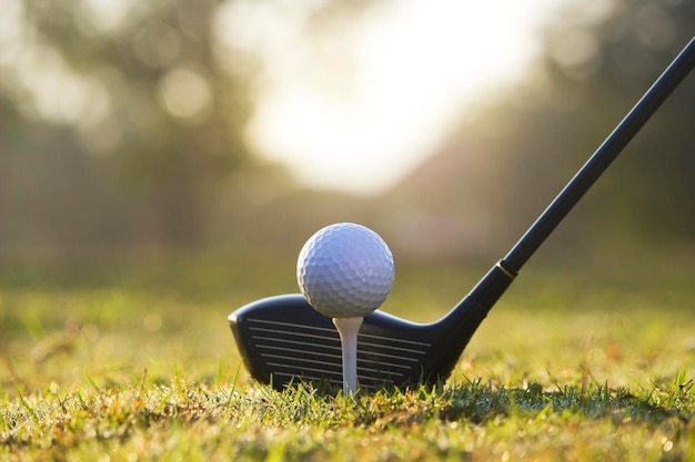 Golf clubs and golf balls on a green lawn in a beautiful golf course